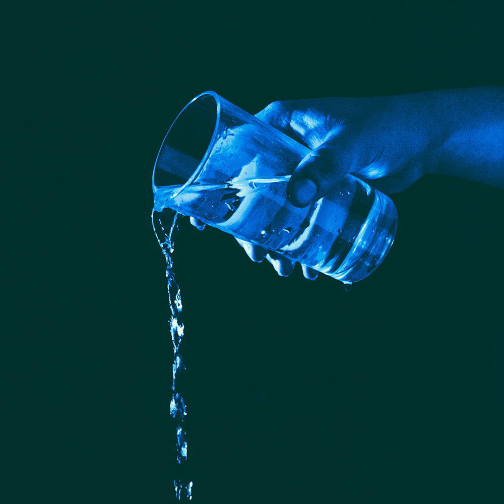 hand pouring glass of water